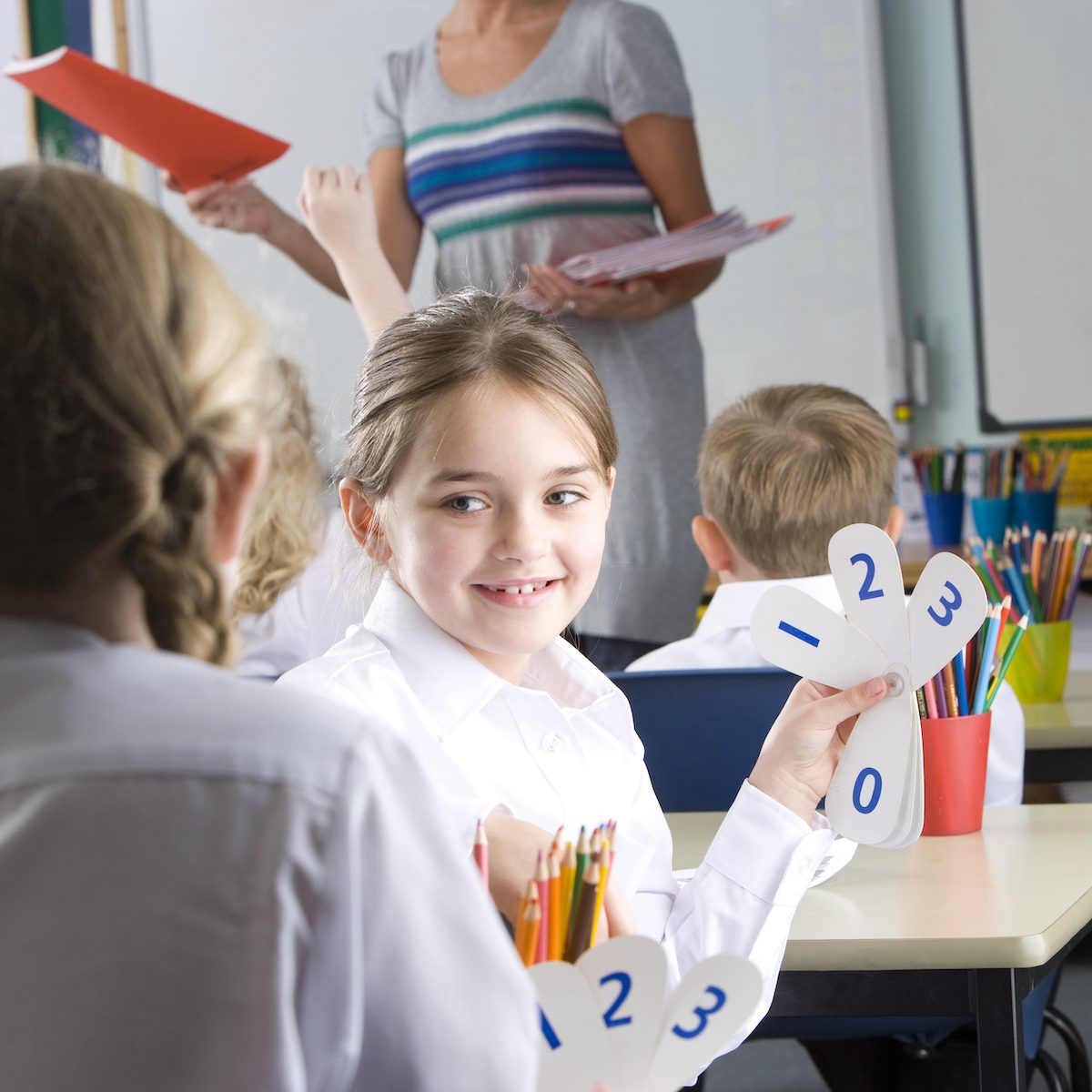 School,Girls,Holding,Number,Cards,At,Desk,In,Classroom